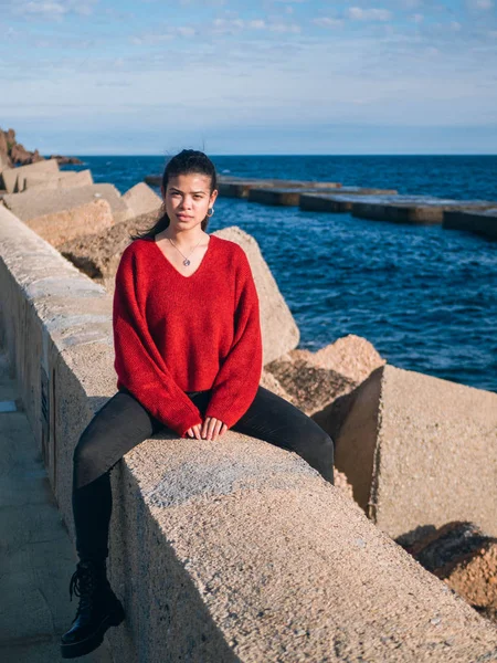 Latina ragazza vicino al mare sedersi sulle rocce — Foto Stock