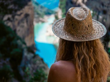 Hasır şapkalı turist kadın turkuaz mavi göl ve manzaranın yanında dinleniyor. Doğa, seyahat, macera, yürüyüş. Mont Rebei 'de.
