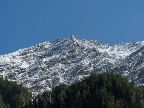 Снегопад на вершине горы и голубое небо — стоковое фото