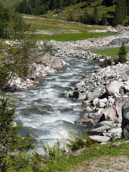 Mountain stream with stone shores in the Alps — ストック写真
