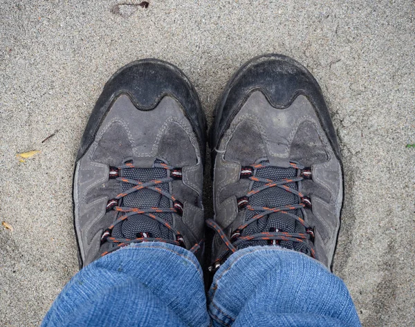 Een paar wandelschoenen op zandgrond — Stockfoto