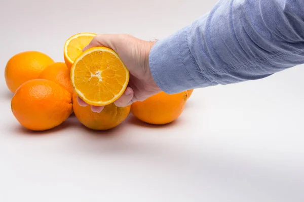 Laranja na mão de uma pessoa adulta, preparando um suco — Fotografia de Stock