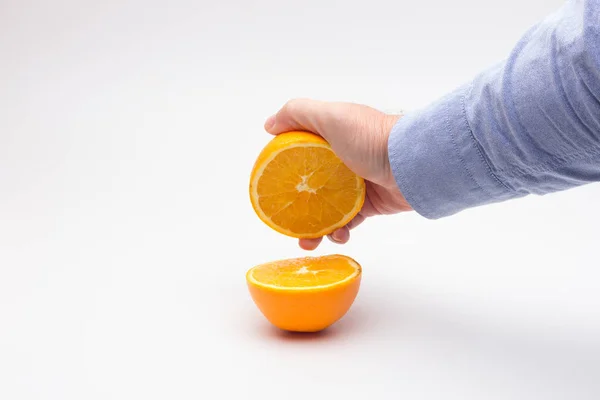 Naranja en la mano de una persona adulta, preparando un jugo — Foto de Stock