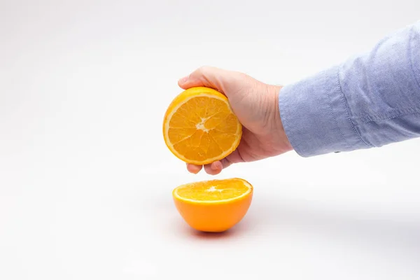 Laranja na mão de uma pessoa adulta, preparando um suco — Fotografia de Stock