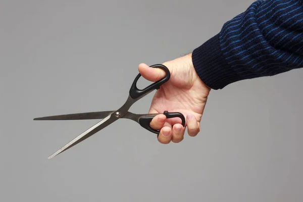 Bir insanın elinde makas.