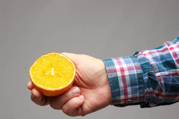 Laranja com a sua pele laranja na mão de um adulto — Fotografia de Stock