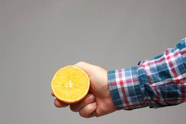 Oranje met oranje huid in de hand van een volwassene — Stockfoto