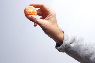 Tangerine slice in the hand of an adult person clipart