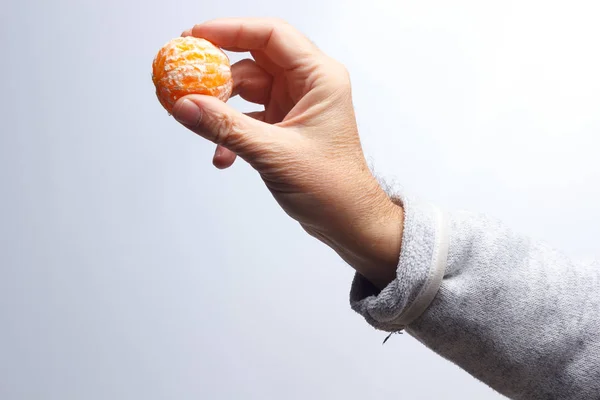 Tangerine slice in the hand of an adult person — Stock Photo, Image