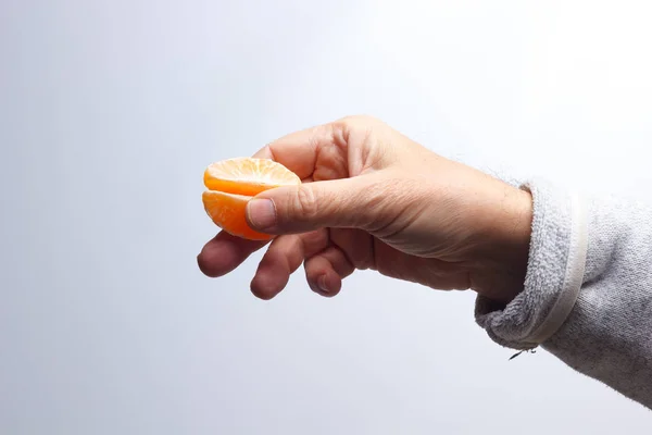 Tangerine in de hand van een volwassene — Stockfoto