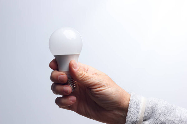 Energy saving light bulb in the hand of an adult