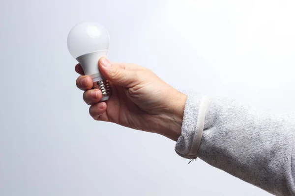 Energiebesparende lamp in de hand van een volwassene — Stockfoto