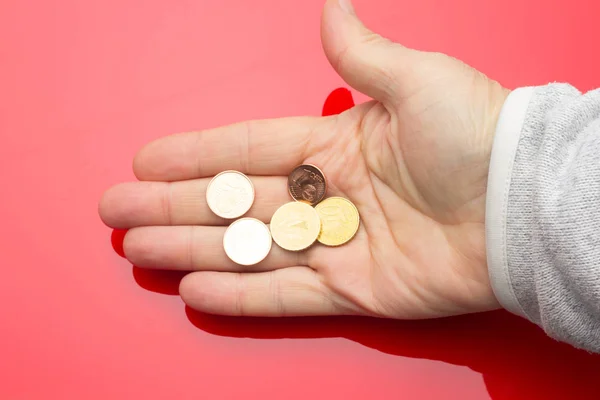 Monedas de euros en la mano de una persona adulta, sobre fondo de color —  Fotos de Stock