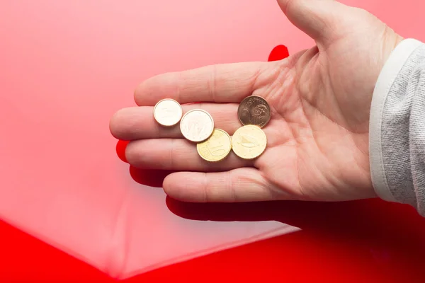 Monedas de euros en la mano de una persona adulta, sobre fondo de color —  Fotos de Stock