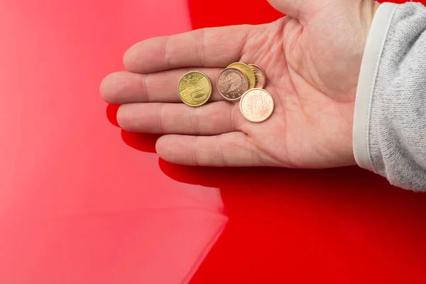Monedas de euros en la mano de una persona adulta, sobre fondo de color —  Fotos de Stock