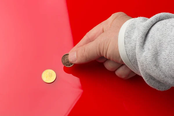 Euromynt i handen på en vuxen person, på färgad bakgrund — Stockfoto