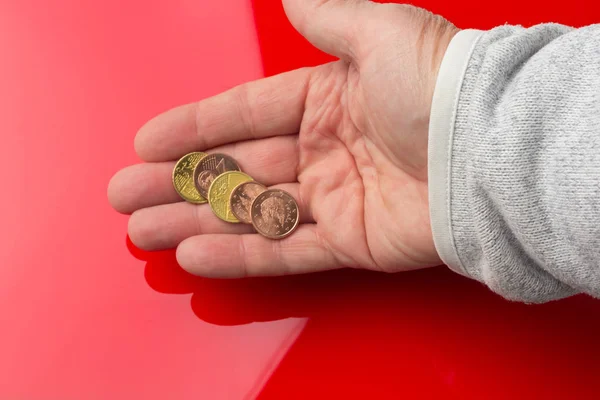 Monedas de euros en la mano de una persona adulta, sobre fondo de color —  Fotos de Stock