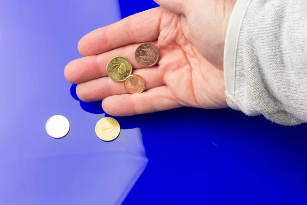 Monedas de euros en la mano de una persona adulta, sobre fondo de color —  Fotos de Stock