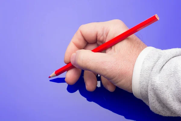 Lápiz de color en la mano de una persona adulta — Foto de Stock