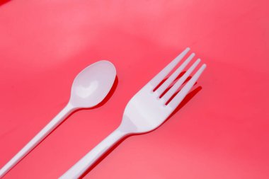 Küçük kahve kaşığı, plastik çatal ve beyaz. Küçük nesneler yemek ve yemek yemek için ve kahve koymak için şeker porsiyonları ölçüsü olarak kullanılır. Yiyecek nesneler ve çatallar.