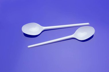 Küçük kahve kaşığı, plastik çatal ve beyaz. Küçük nesneler yemek ve yemek yemek için ve kahve koymak için şeker porsiyonları ölçüsü olarak kullanılır. Yiyecek nesneler ve çatallar.