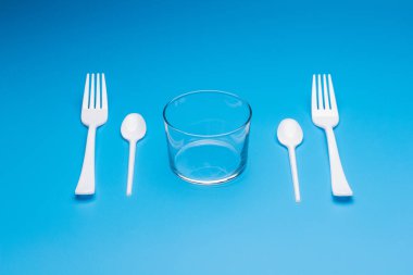 Cutlery for eating white and made of plastic and transparent glass cups; Cutlery and glasses teaspoons for coffee and for rationing small amounts of sugar, fork for pricking food, glasses for drinking
