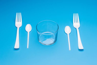 Cutlery for eating white and made of plastic and transparent glass cups; Cutlery and glasses teaspoons for coffee and for rationing small amounts of sugar, fork for pricking food, glasses for drinking