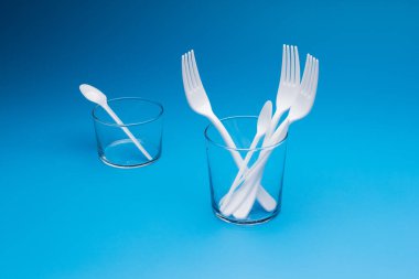 Cutlery for eating white and made of plastic and transparent glass cups; Cutlery and glasses teaspoons for coffee and for rationing small amounts of sugar, fork for pricking food, glasses for drinking