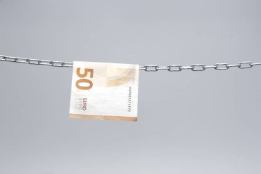 Avro banknotları, Avrupa ekonomisinin para birimi, 50, 20, 10 ve 5 avroluk bir zincirde asılı duruyor. Zincirlenmiş bir cımbızla asılı duran kağıt para..