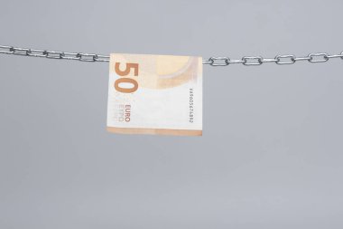 Avro banknotları, Avrupa ekonomisinin para birimi, 50, 20, 10 ve 5 avroluk bir zincirde asılı duruyor. Zincirlenmiş bir cımbızla asılı duran kağıt para..