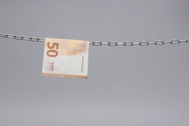 Avro banknotları, Avrupa ekonomisinin para birimi, 50, 20, 10 ve 5 avroluk bir zincirde asılı duruyor. Zincirlenmiş bir cımbızla asılı duran kağıt para..