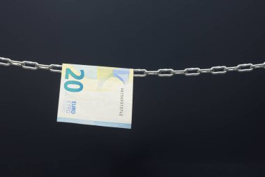 Money held in a chain or hung on a chain; paper money legal tender; Euros, currency of the European economic community, Common market.
