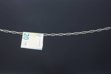 Money held in a chain or hung on a chain; paper money legal tender; Euros, currency of the European economic community, Common market.