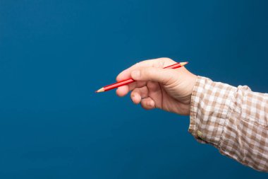 Kağıt üzerine çizim yapmak temel elementlerden biridir. Renkli kalemler. Yetişkin birinin elinde renkli kalem.