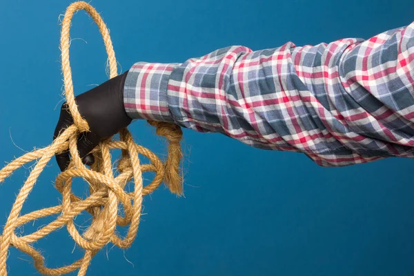 Yellow rope in the expert hand of an adult with protection. Thick rope to tie objects.