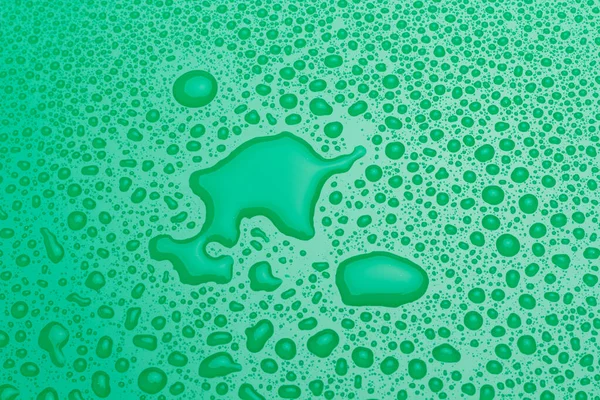 光沢のある緑色の表面に小さく不規則な水滴 — ストック写真
