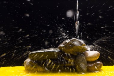 Kristal berrak, içilebilir ve şeffaf su, bazı taşların üzerine düşmek ve su sıçratma ve sıçrama nedeniyle binlerce damla oluşturur.