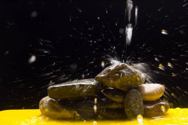 Kristal berrak, içilebilir ve şeffaf su, bazı taşların üzerine düşmek ve su sıçratma ve sıçrama nedeniyle binlerce damla oluşturur.