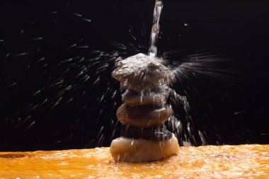 Kristal berrak, içilebilir ve şeffaf su, bazı taşların üzerine düşmek ve su sıçratma ve sıçrama nedeniyle binlerce damla oluşturur.