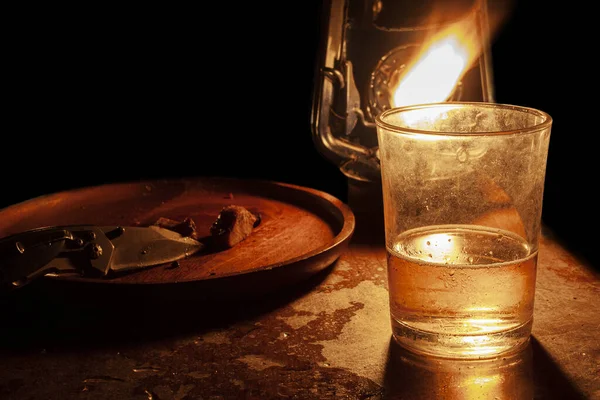 晚上在木制桌子上喝一杯水 一块牛排和一个灯笼 — 图库照片