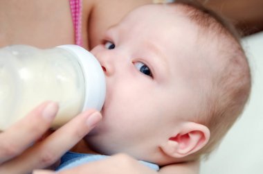 Küçük bir çocuk bir meme süt içiyor