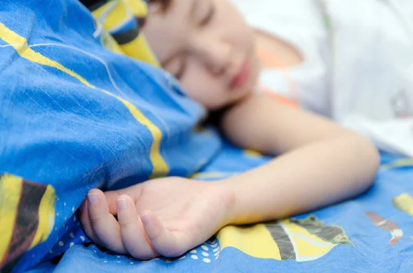 Een kleine jongen is slapen in zijn bed — Stockfoto