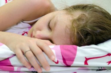 küçük kız yatağında uyuyor