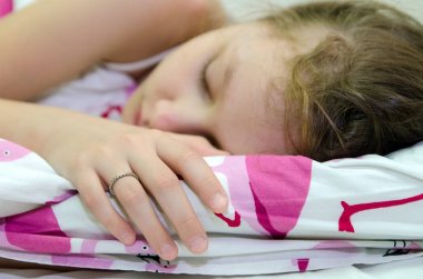 küçük kız yatağında uyuyor