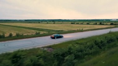 Bmw aracını takip eden İHA tarlaların yakınındaki asfalt yolda ilerliyor. Rusya. 