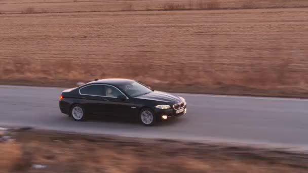 Drone Beelden Van Bmw Serie Zwarte Auto Rijden Weg Zonnestralen — Stockvideo