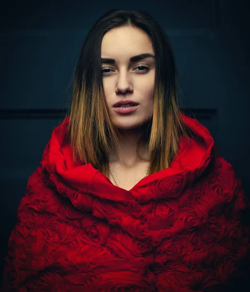 Beautiful woman red cloak with red flowers roses in studio — Stock Photo, Image