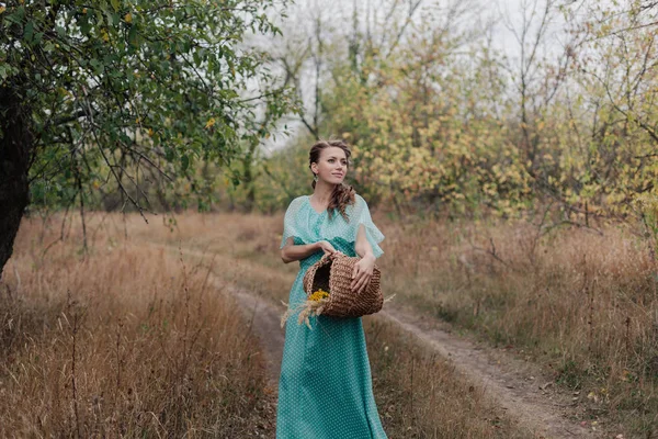 長いエレガントな身に着けているロマンチックな女性のドレス フィールド、秋のシーズン、リラクゼーションの上に立って楽しんで喜び概念自然の田園地帯に — ストック写真