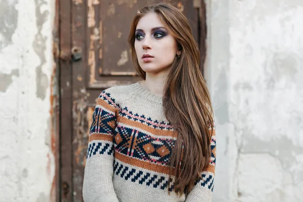 Krásná žena s dlouhými vlasy v zimě svetr. Zdravé vlasy. Šedé pozadí — Stock fotografie