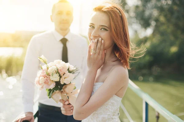 Bruden och brudgummen står på bron — Stockfoto